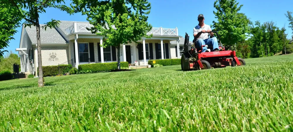 Homeowner with healthy, green spring lawn